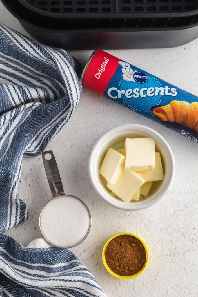 Ingredients needed to make cinnamon crescent rolls measured out on a marble table