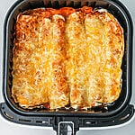 Air fryer enchiladas in the basket, ready to serve.