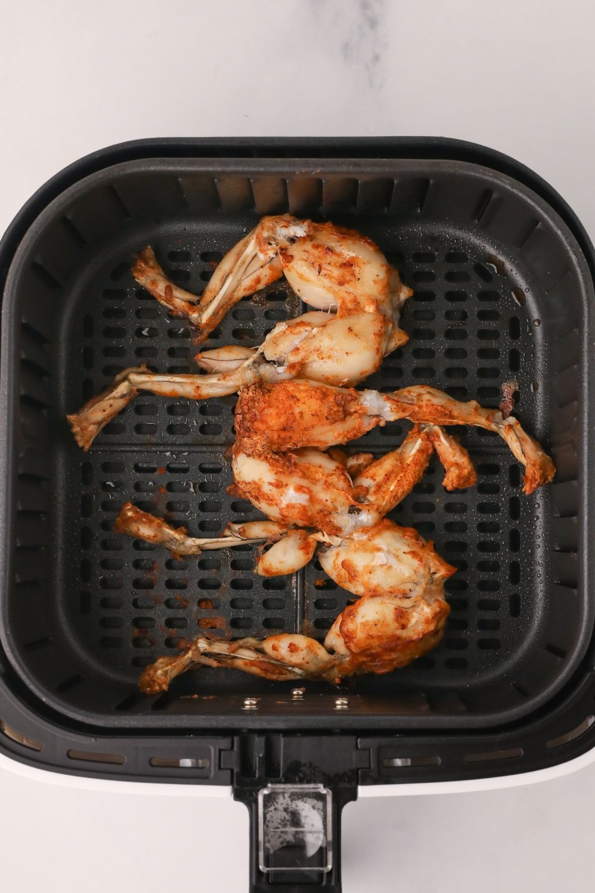 Cooked frog legs in the air fryer basket