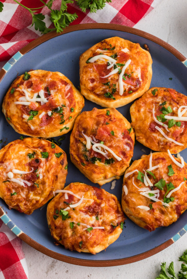 Overhead photo of air fryer mini pizzas on a blue plate.