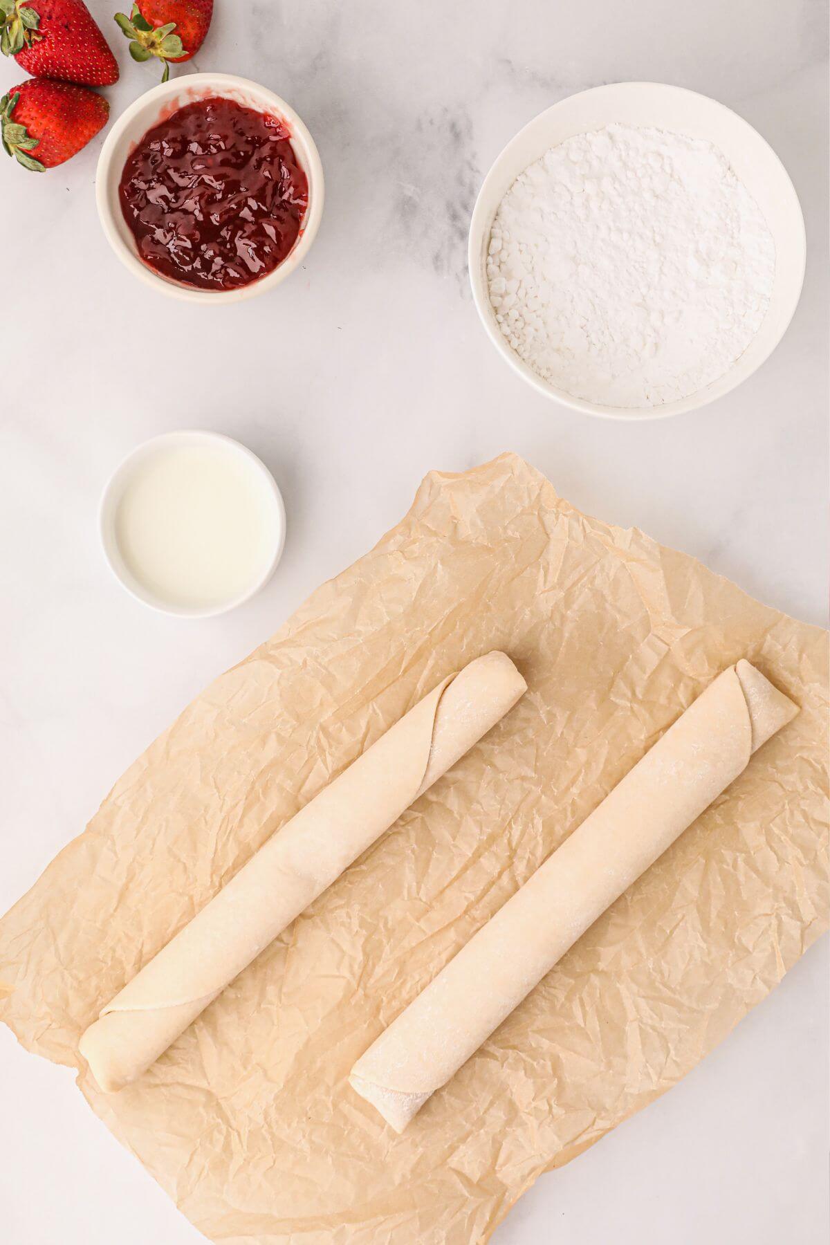 Ingredients needed to make pop tarts, crust, jam filling, powdered sugar and milk for the glaze. 