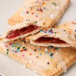 Golden pop tart pastries glazed and cut in half with strawberry jam filling