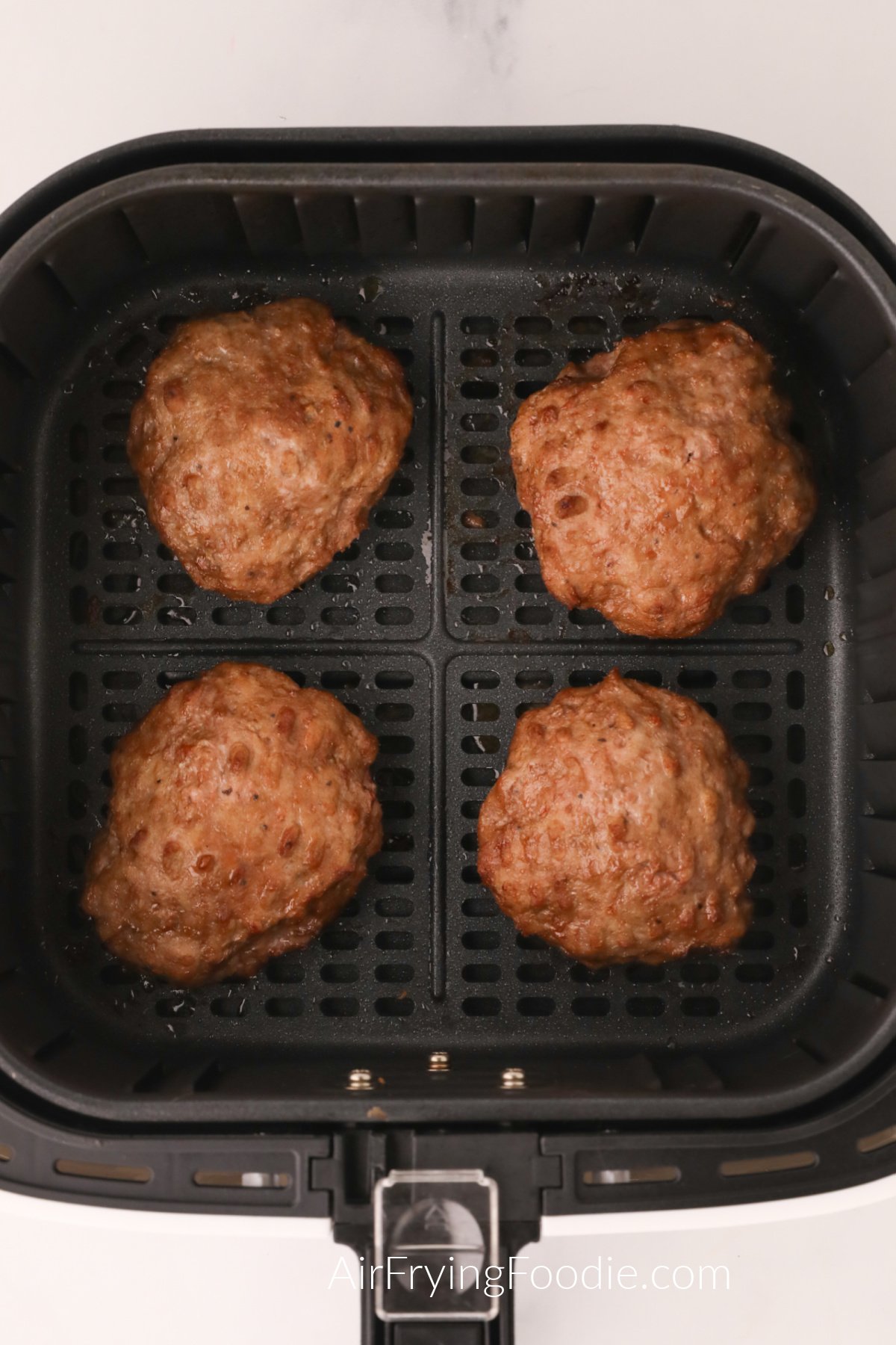 Fried Turkey Burgers in the basket of the air fryer.