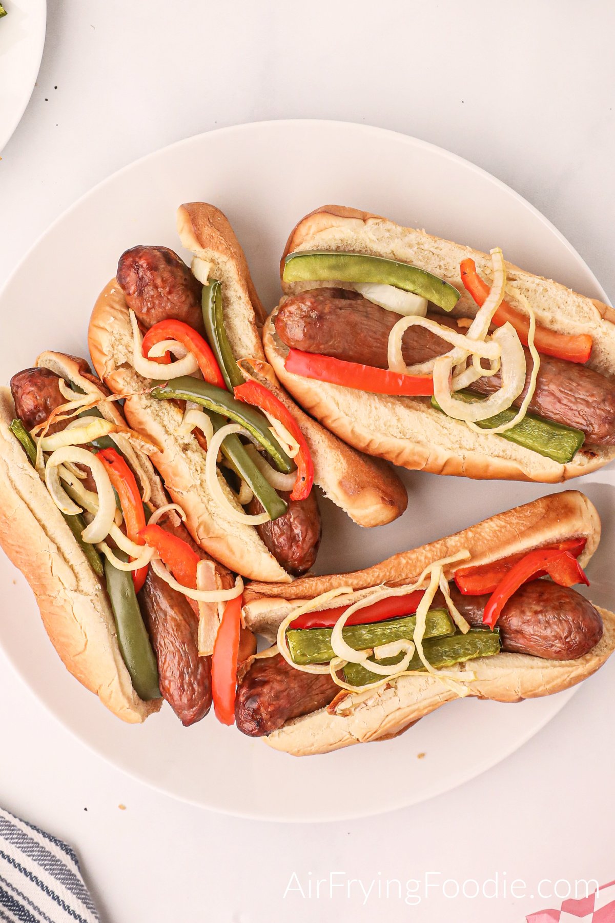 Overhead shot of Air Fryer Italian Sausage served with peppers and onions on buns. Ready to serve.