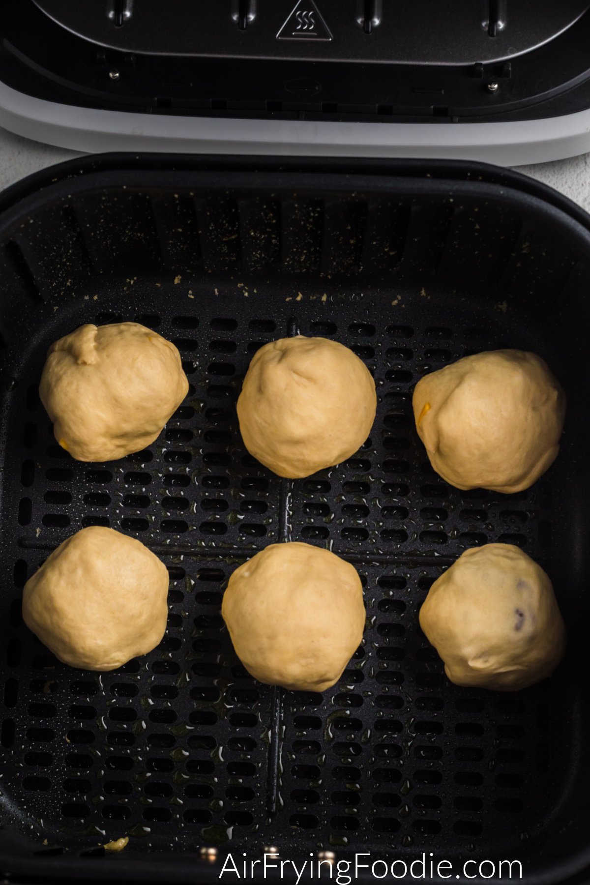 Cheeseburger balls in the basket of the air fryer ready to be cooked.