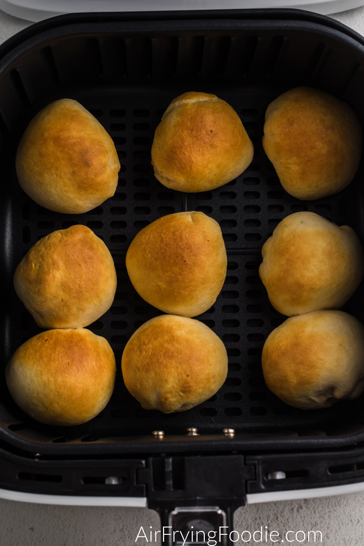 Cheeseburger bombs in the basket of the air fryer.
