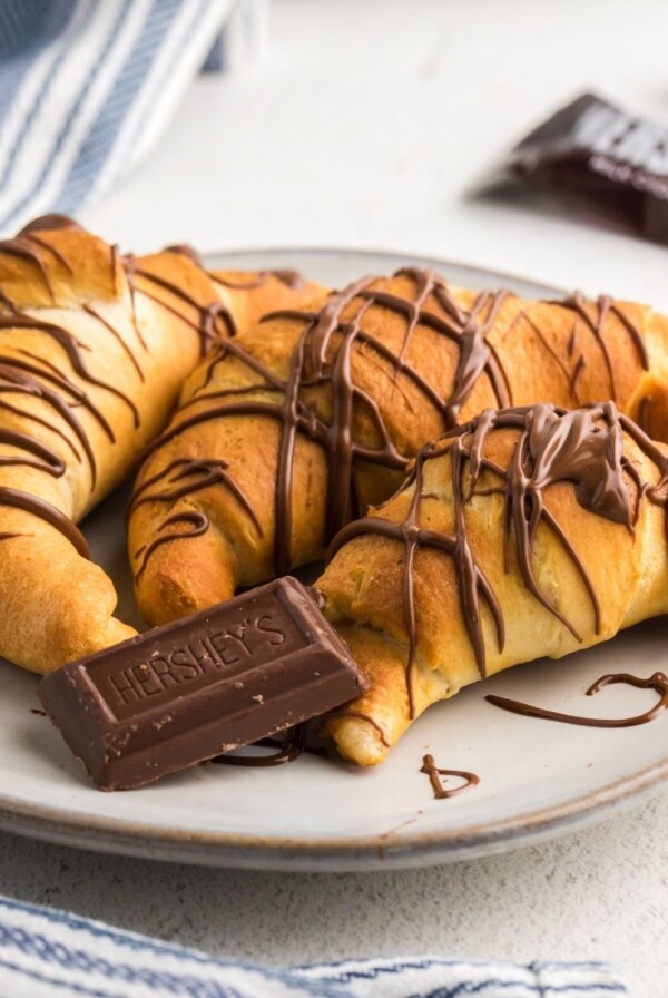 Golden chocolate drizzled crescent rolls in the shape of croissants