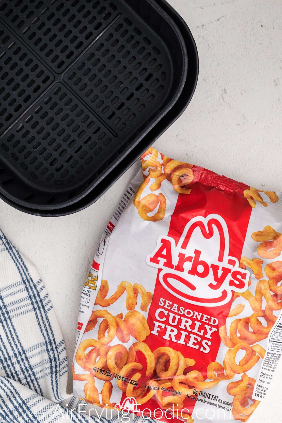Air Fryer Basket and a bag of frozen curly fries from Arby's. 