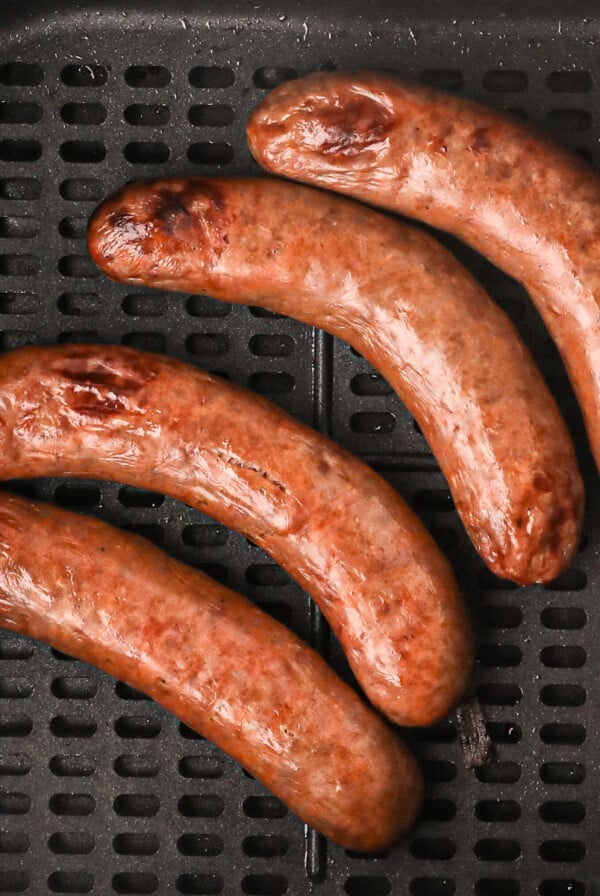 Italian Sausage in air fryer basket ready to eat.