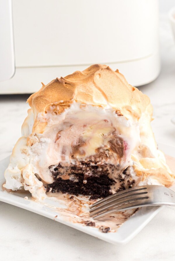 Golden meringue coating over ice cream on a brownie in front of an air fryer