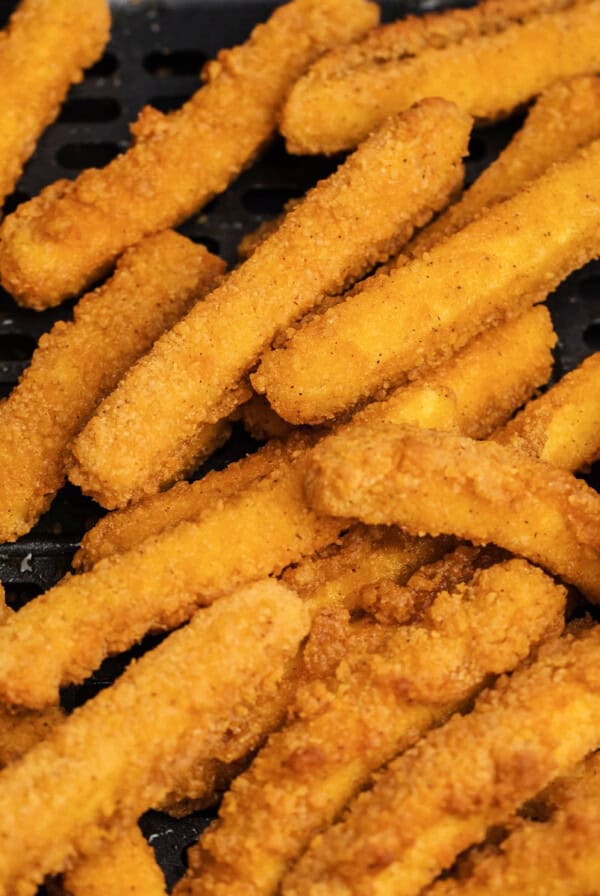 Cooked chicken fries in air fryer basket.