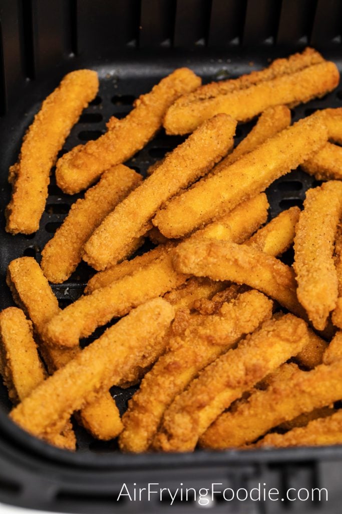 Chicken Fries in air fryer basket, fully cooked and ready to serve.