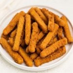 Crispy air fried chicken fries on a white plate, ready to eat.