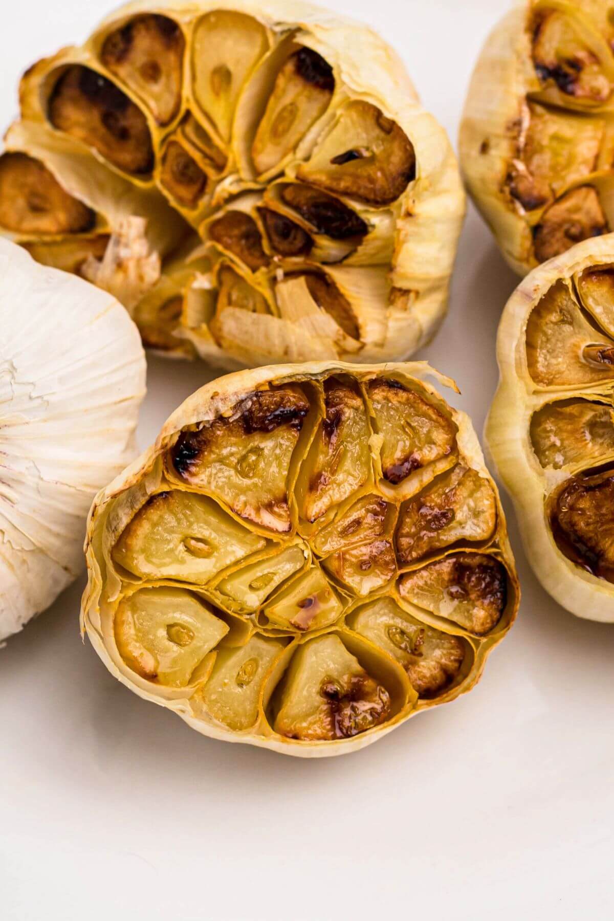 Golden roasted garlic heads on a marble table 