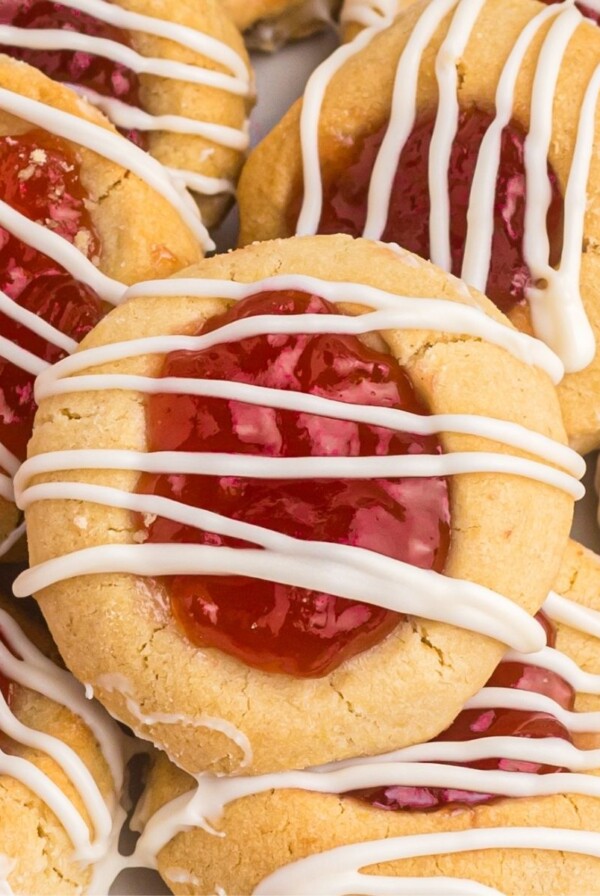 Golden cookies topped with seedless jam and drizzled with white chocolate