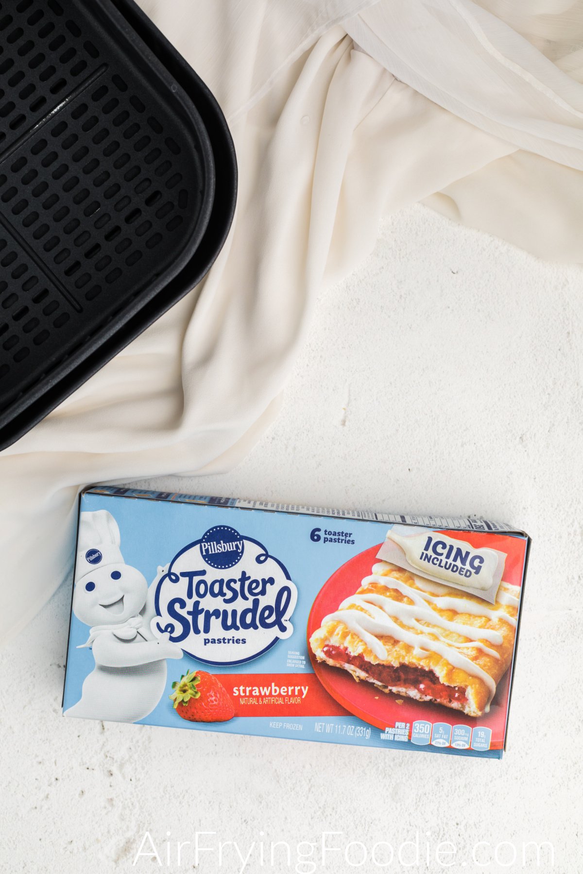 Air fryer basket and Pillsbury toaster strudel in a box, ready to cook. 