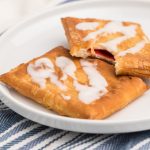 Toaster strudel made in the air fryer on a white plate with a missing bite.