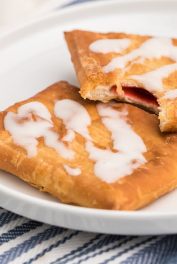 Toaster strudel made in the air fryer on a white plate with a missing bite.