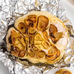 Golden garlic bulb in a piece of foil drizzled and roasted in the air fryer