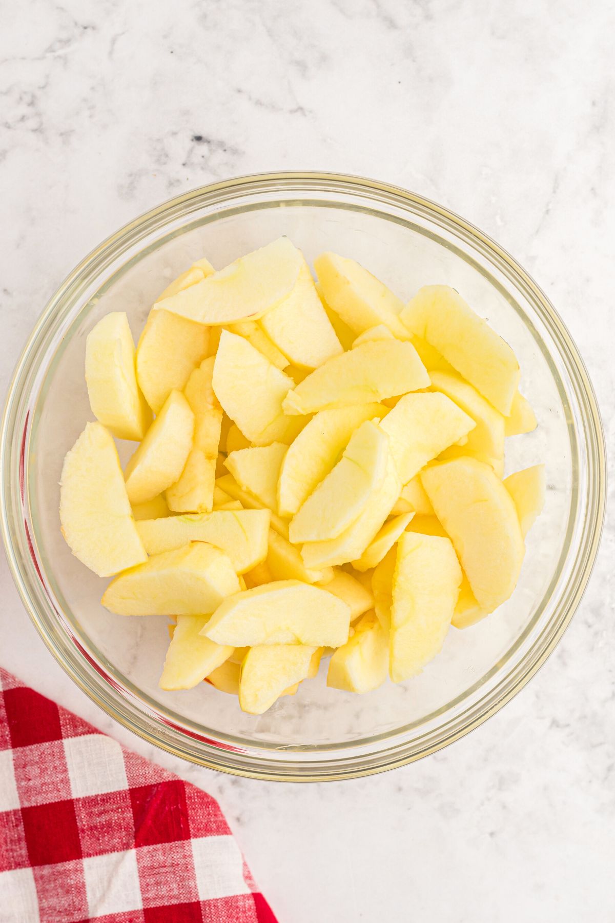 Apples cut into small slices in a clear glass bowl