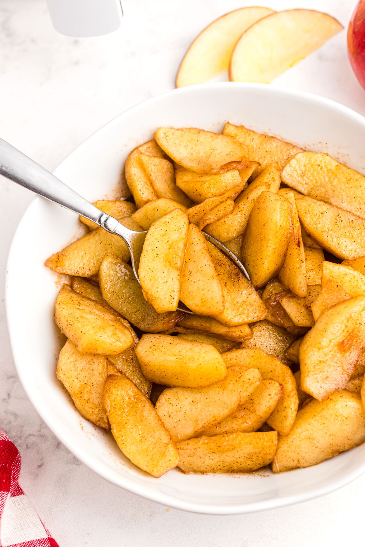 Air fried apples in a white bowl with a spoon, ready to serve. 