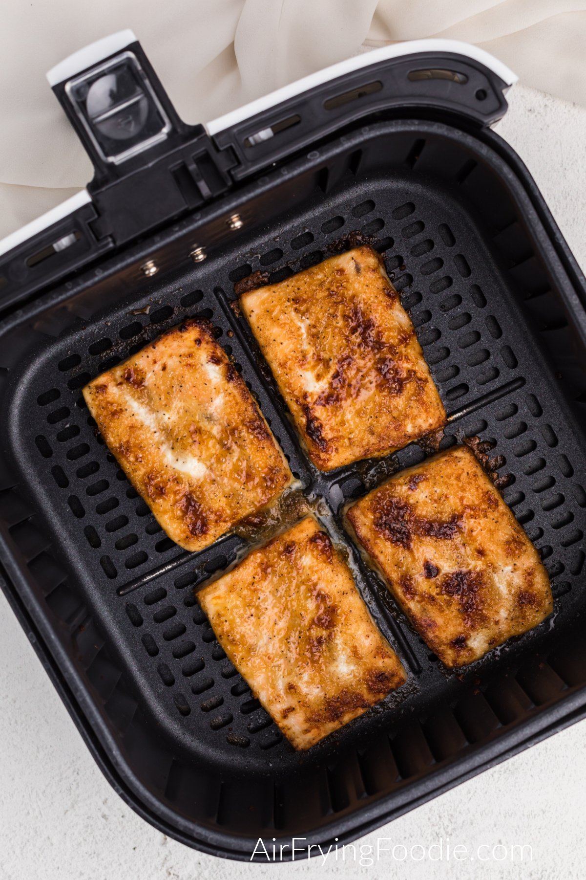fully cooked from frozen salmon in air fryer basket ready to serve.