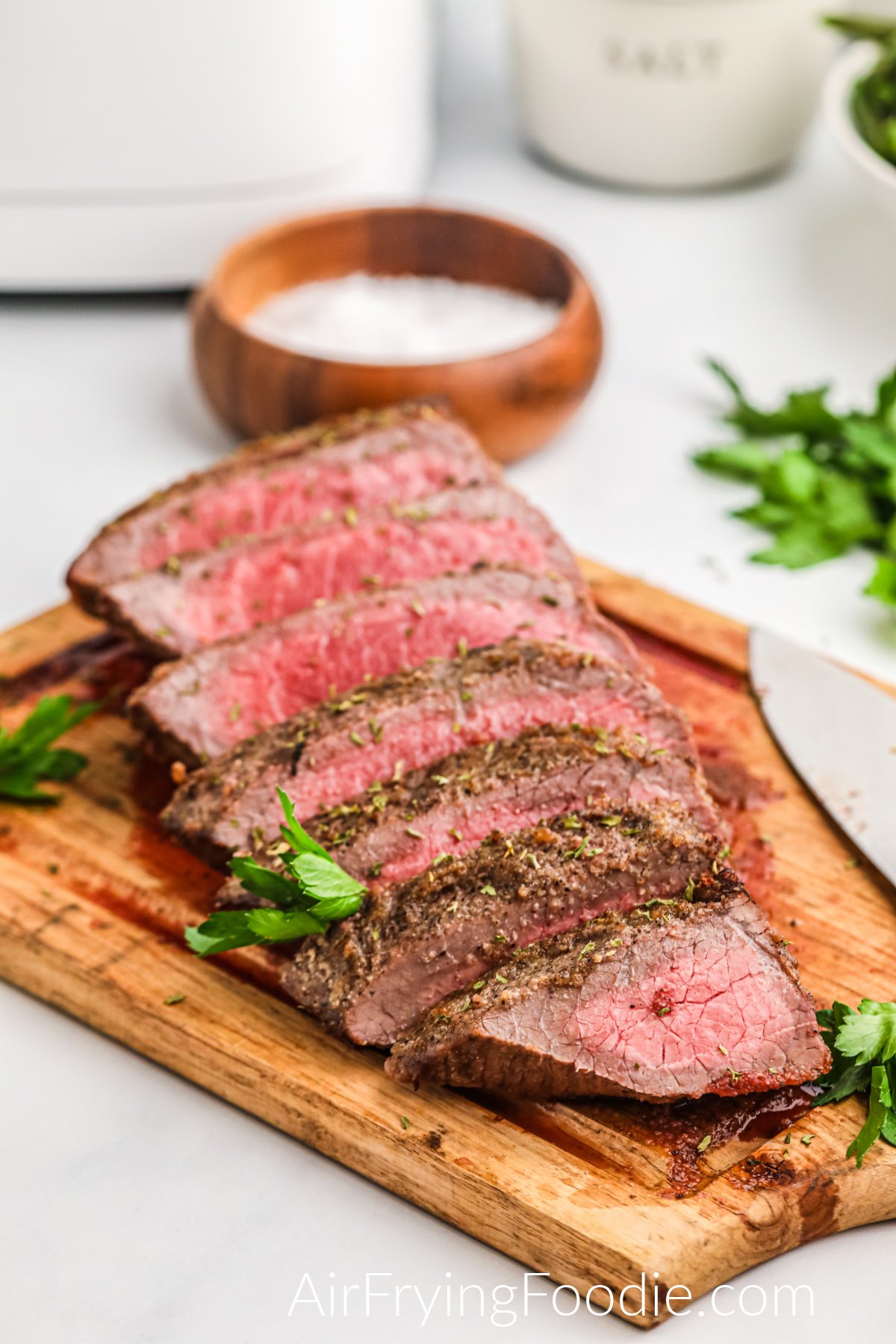 Seasoned and sliced Air Fryer London Broil on a cutting board. 