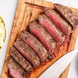 Air fryer London broil sliced and served on a cutting board, ready to eat.