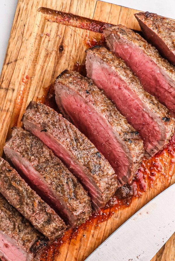 Air fryer London broil sliced and served on a cutting board, ready to eat.