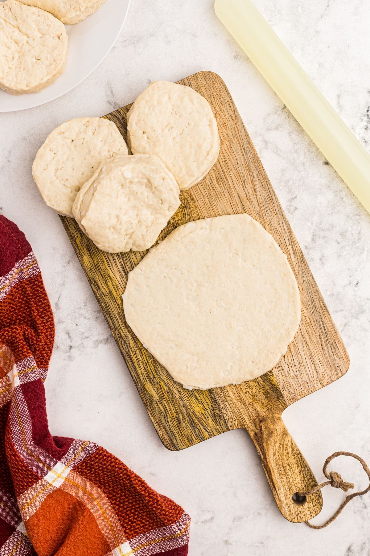 Rolled biscuit dough on a wooden cutting board