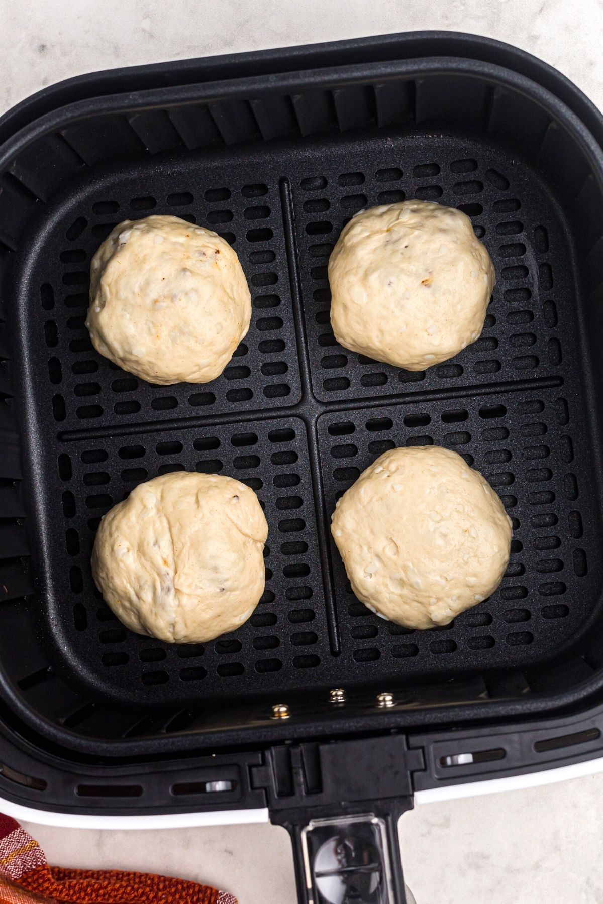 Raw biscuit dough filled with meat and cheese in the air fryer basket