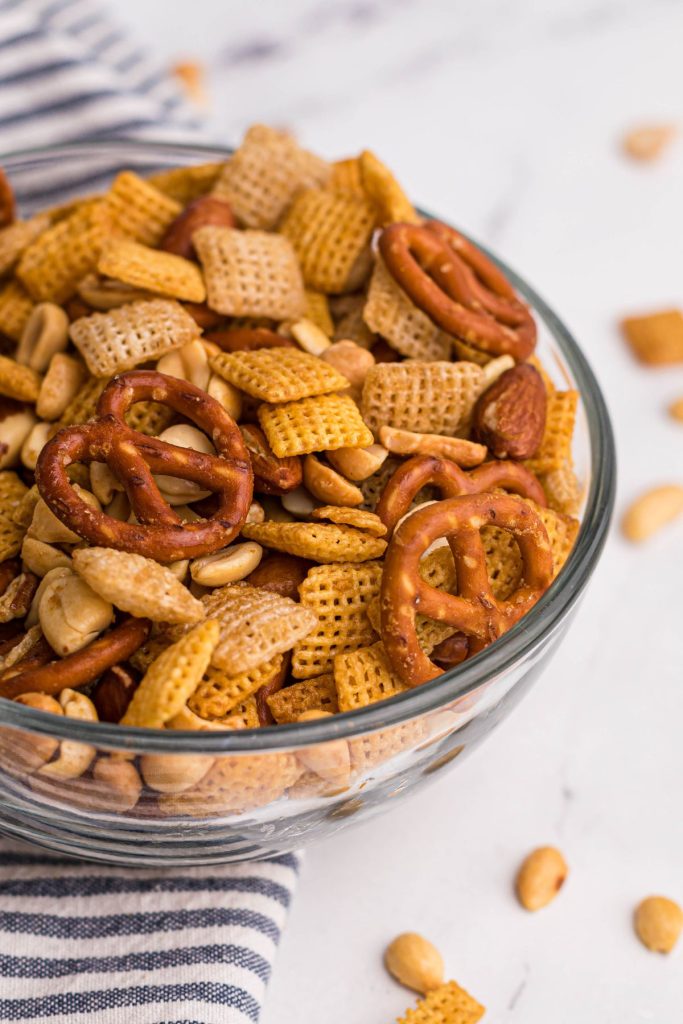Air fried chex mix in a clear bowl after being cooked with seasonings. 