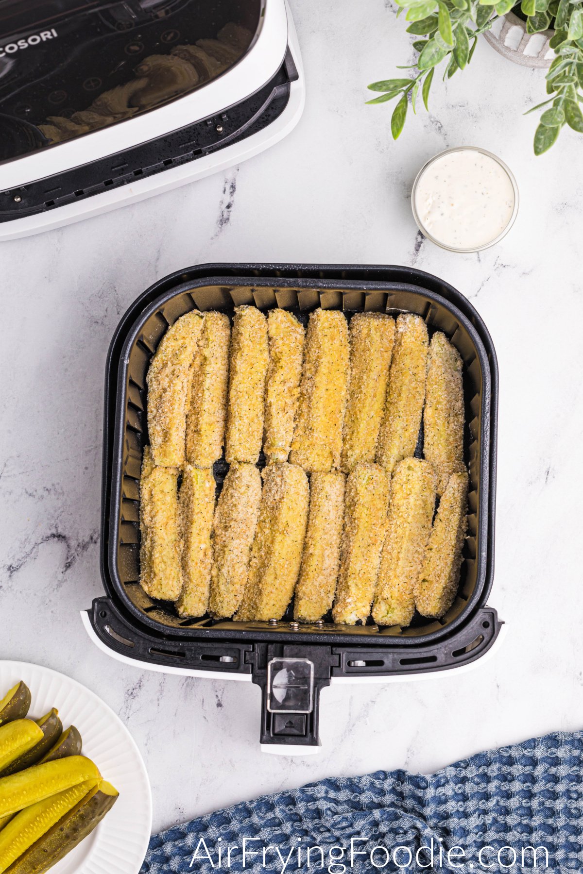 Dipped dill pickle spears in a single layer in the air fryer basket.