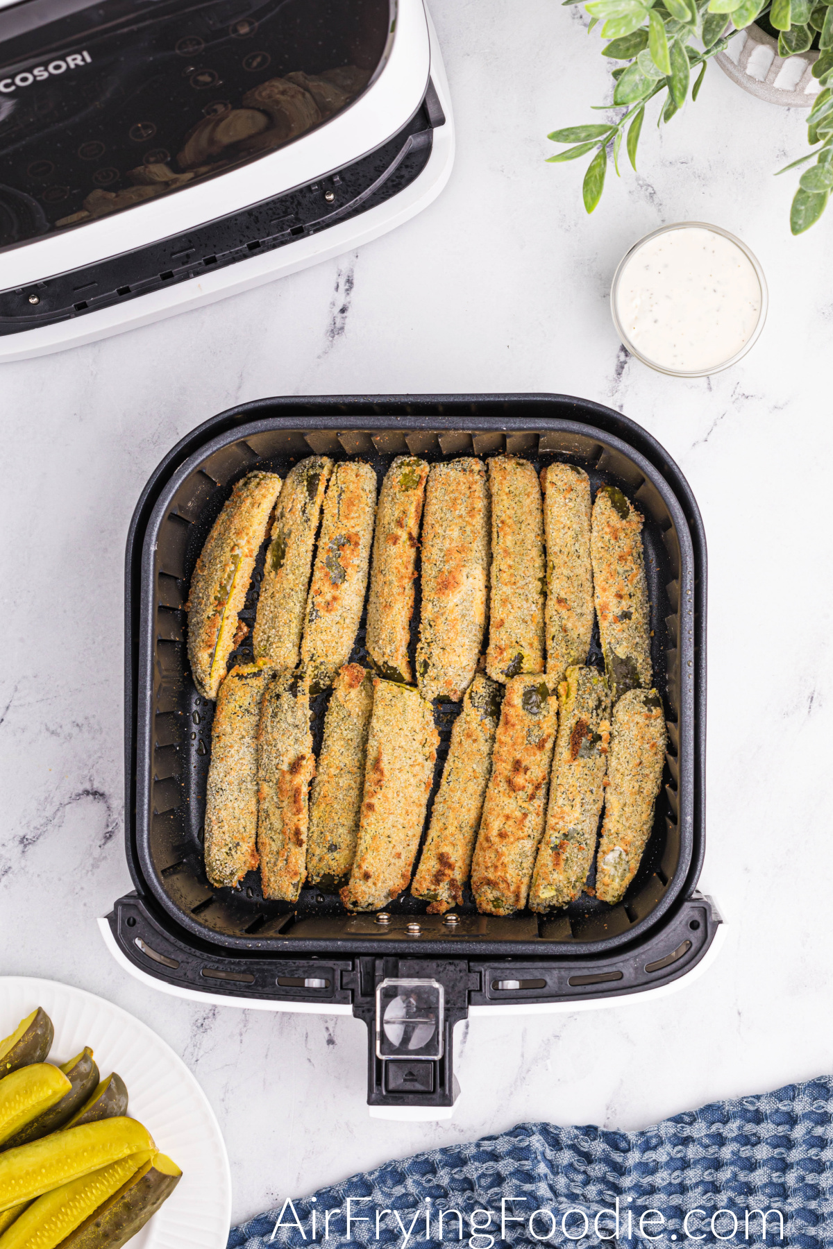 Crispy air fryer dill pickle spears in the basket of the air fryer.