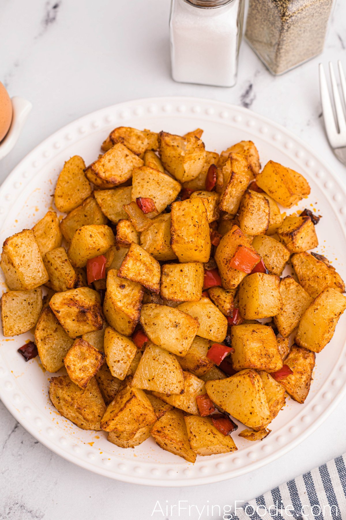 Air fried home fries on a white plate, ready to serve.