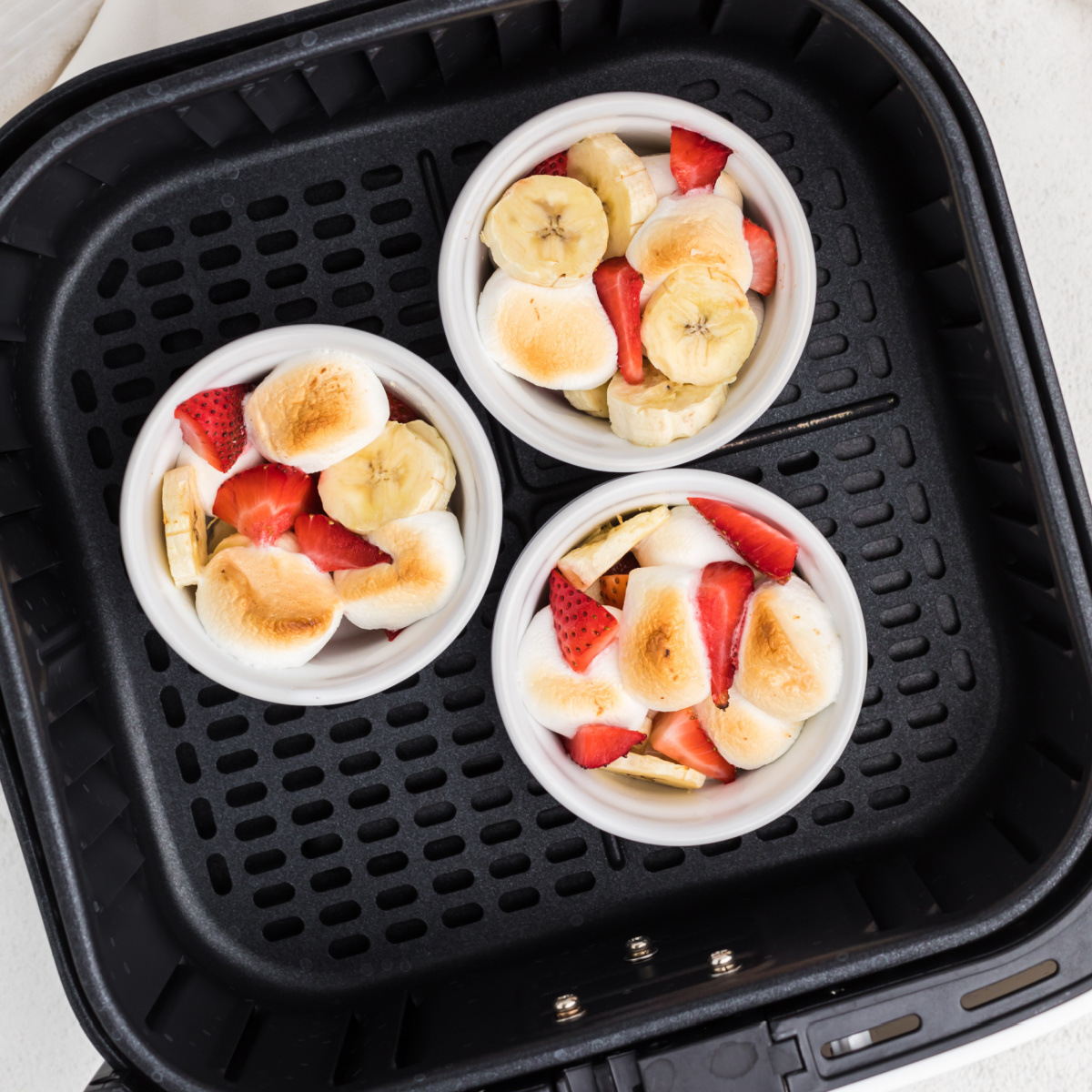 Strawberry Banana Bowls in the basket of the air fryer.