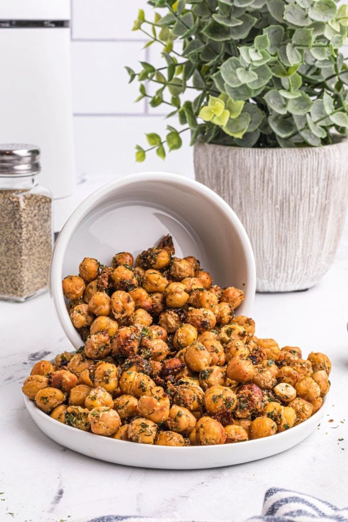 Crispy chickpeas in a white bowl spilling onto a small white plate