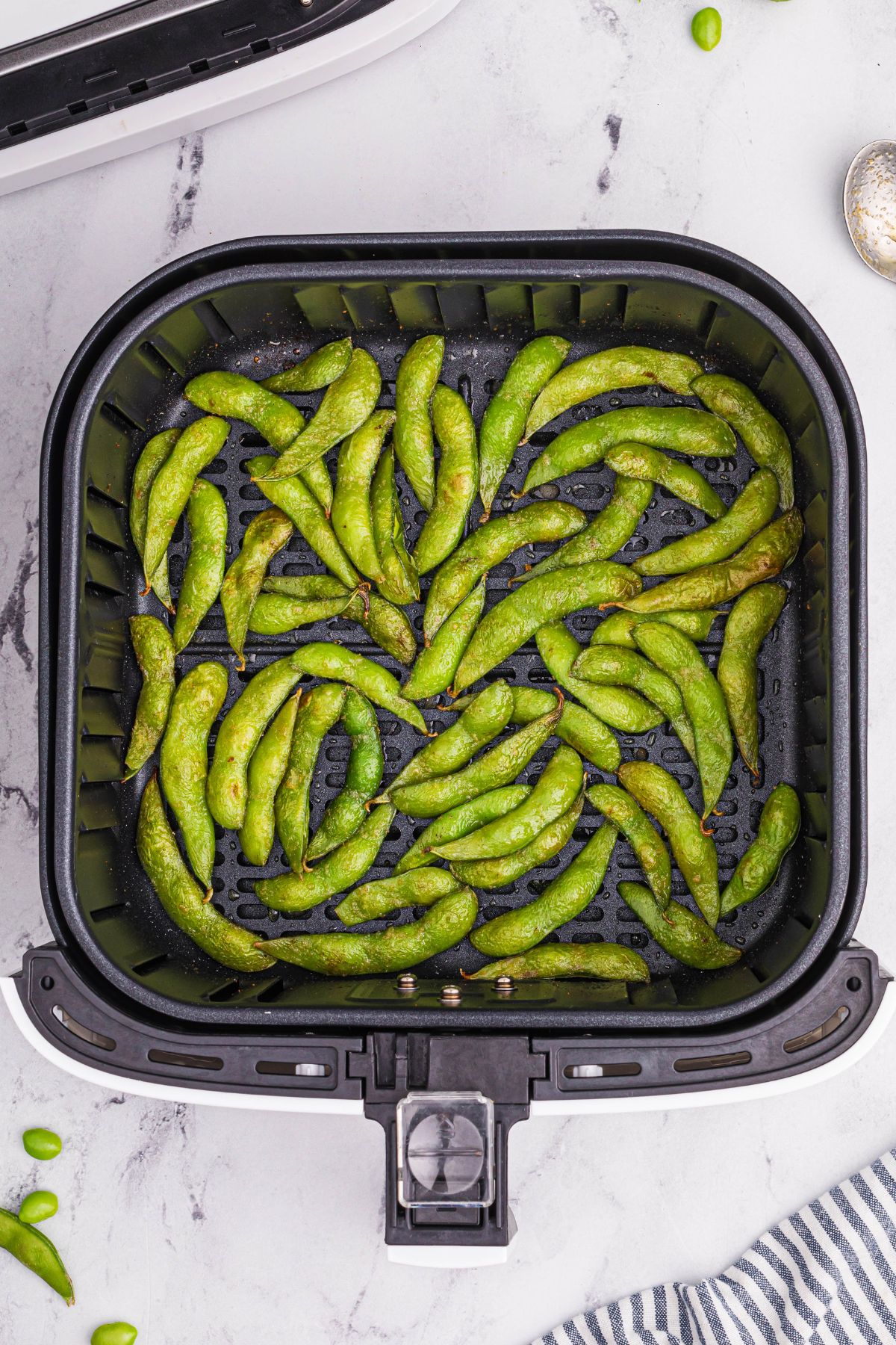 Air fried edamame pods in the air fryer basket