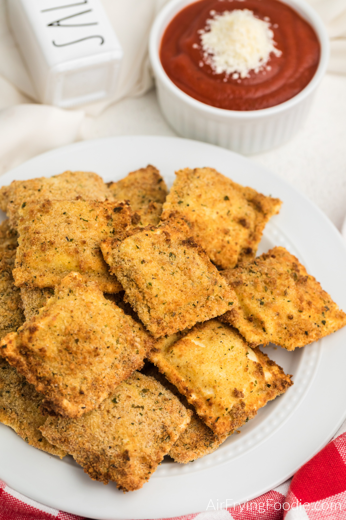 Air fried ravioli on a white plate, ready to serve.
