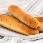 Breadsticks made in the air fryer on a white plate.