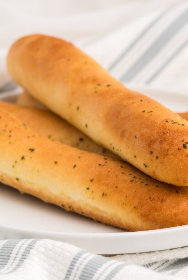 Breadsticks made in the air fryer on a white plate.