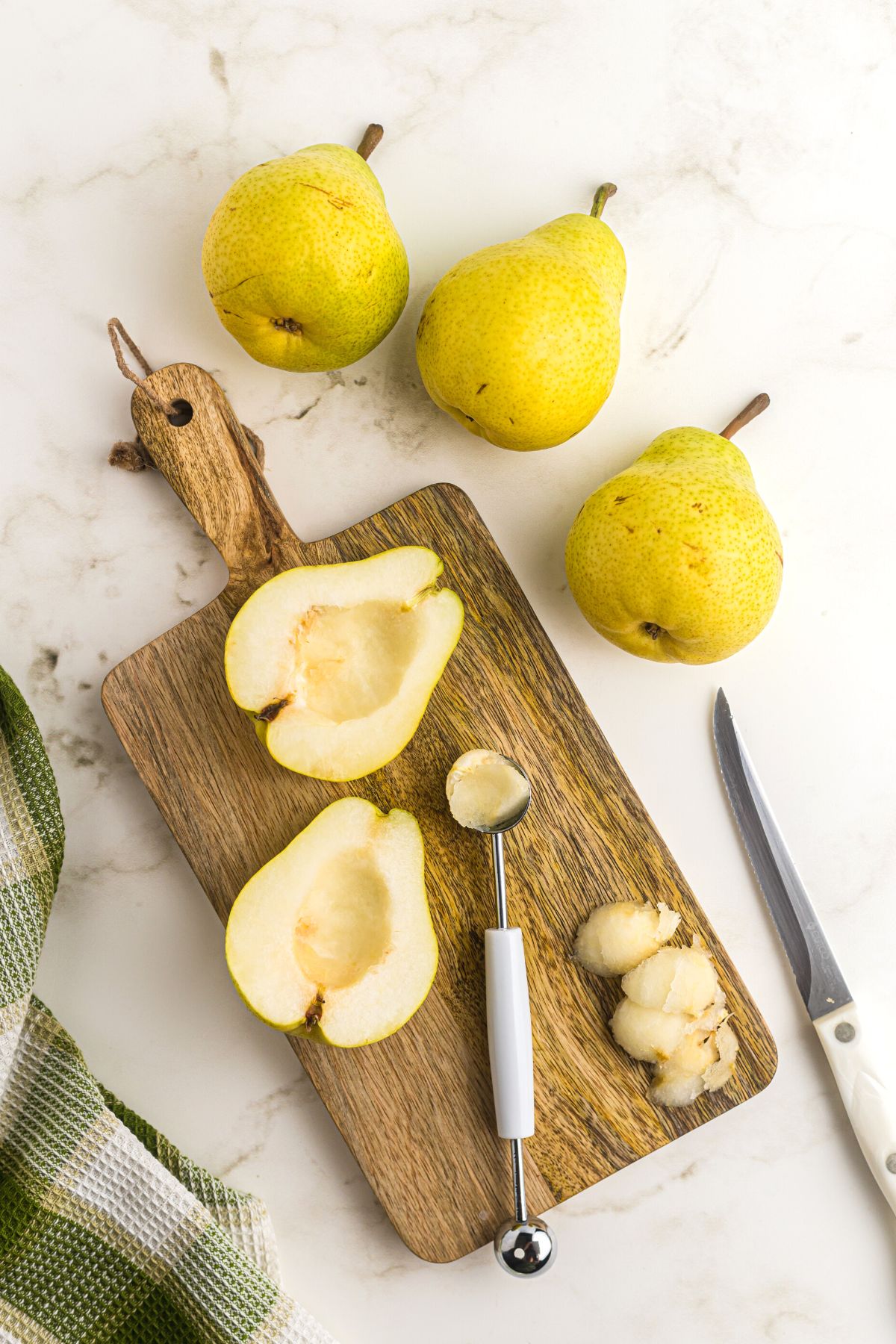 pears on a wooden cutting board sliced in half and cored