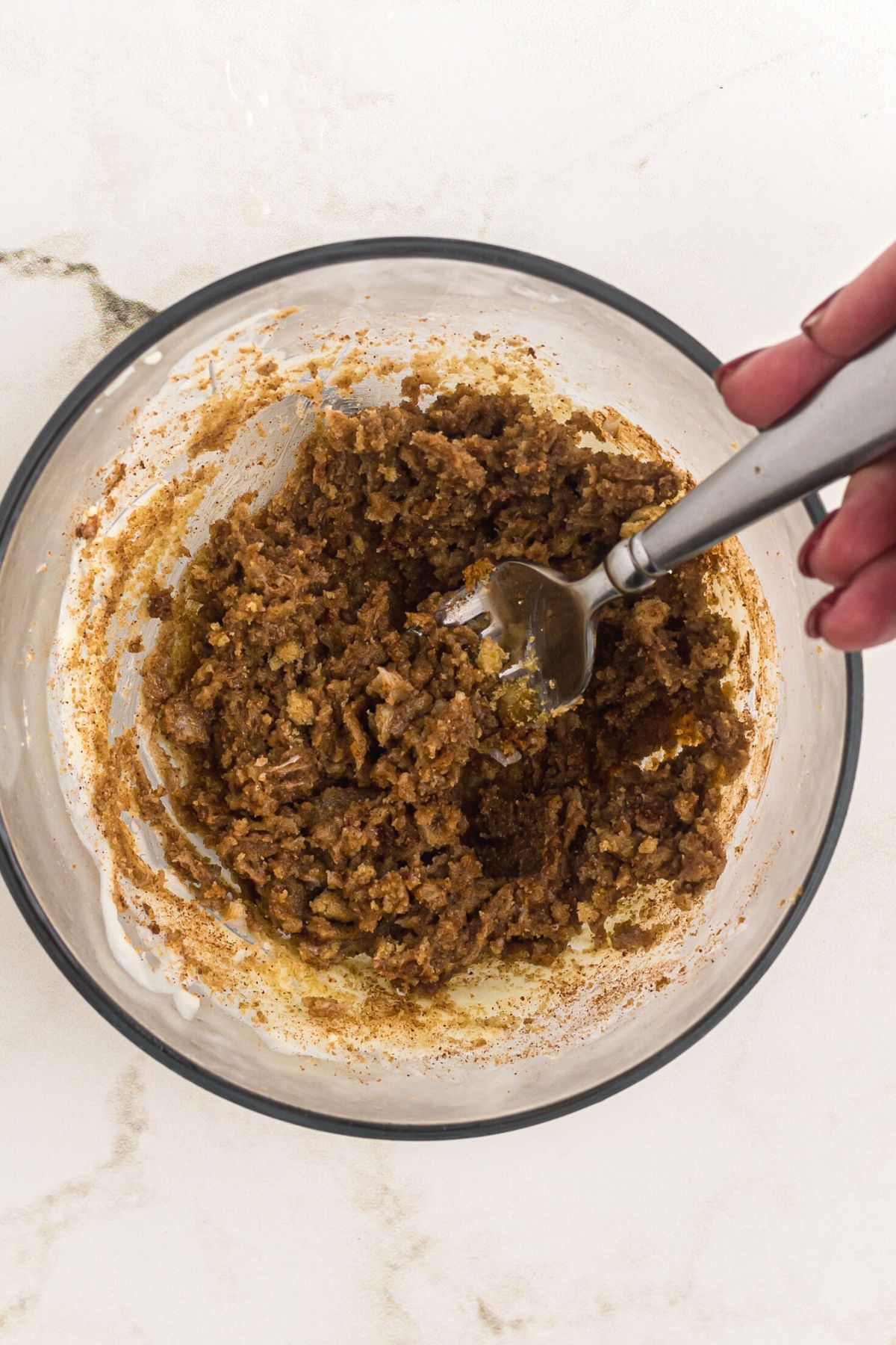 Butter, brown sugar, and cinnamon mixed in a clear glass bowl