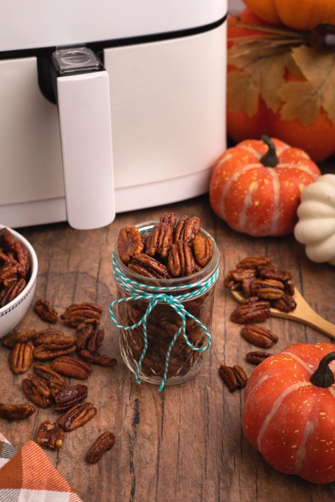 Golden juicy pecans in a small jar after being cooked in the air fryer