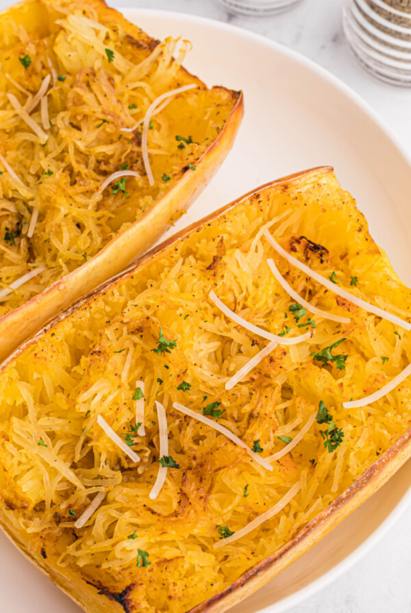 Overhead of spaghetti squash on a white plate, ready to serve.