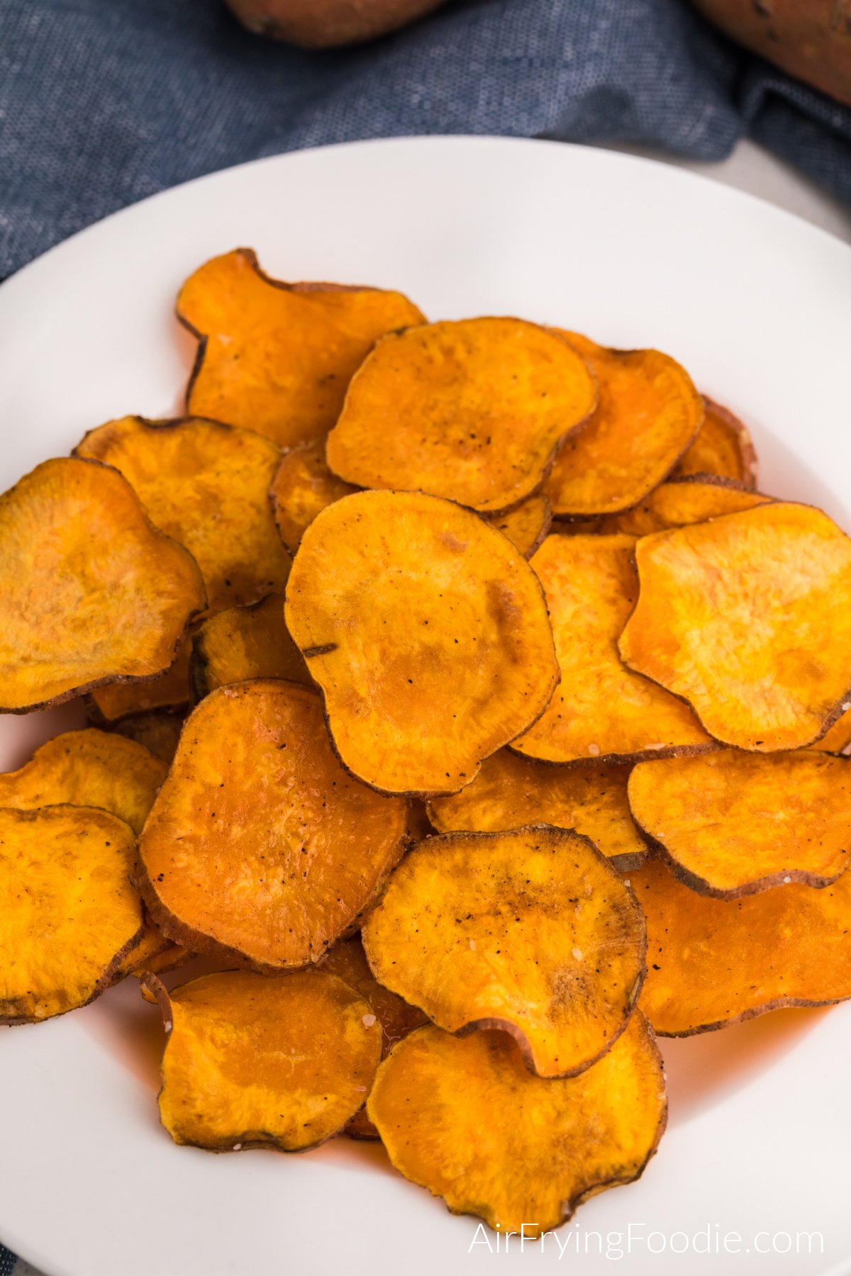 Seasoned air fryer sweet potato chips in a white bowl, ready to serve.