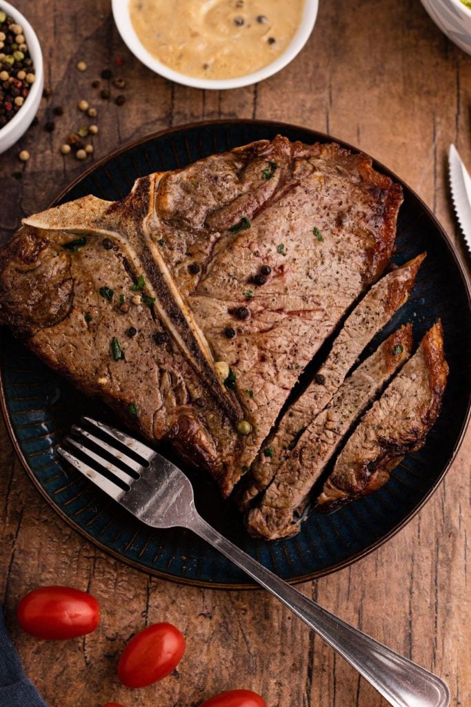 Juicy tbone steak cooked and served on a blue plate 