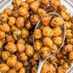 Golden crispy brown chickpeas in a white bowl with a serving spoon