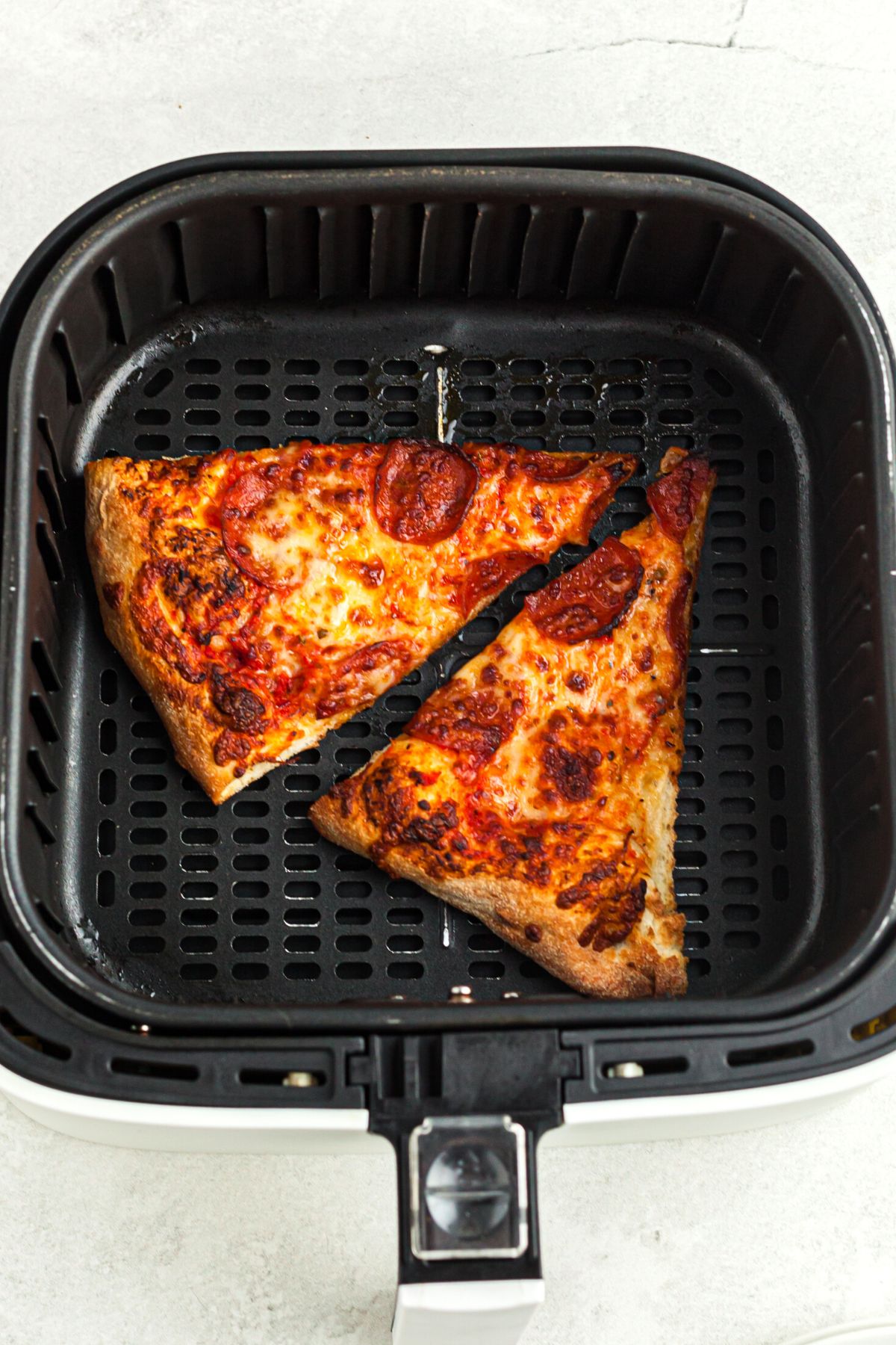 Crispy cooked pizza in the air fryer basket
