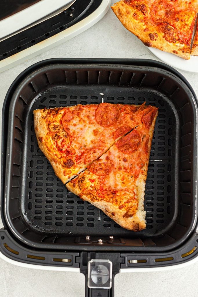 uncooked pizza slices in the air fryer basket